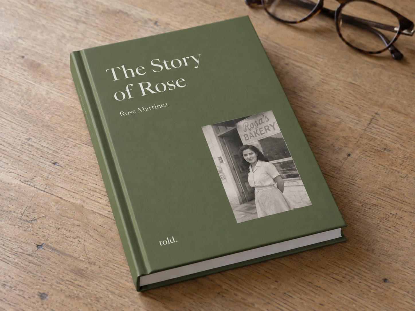 The Story of Rose, a matte olive hardcover on a wooden table.